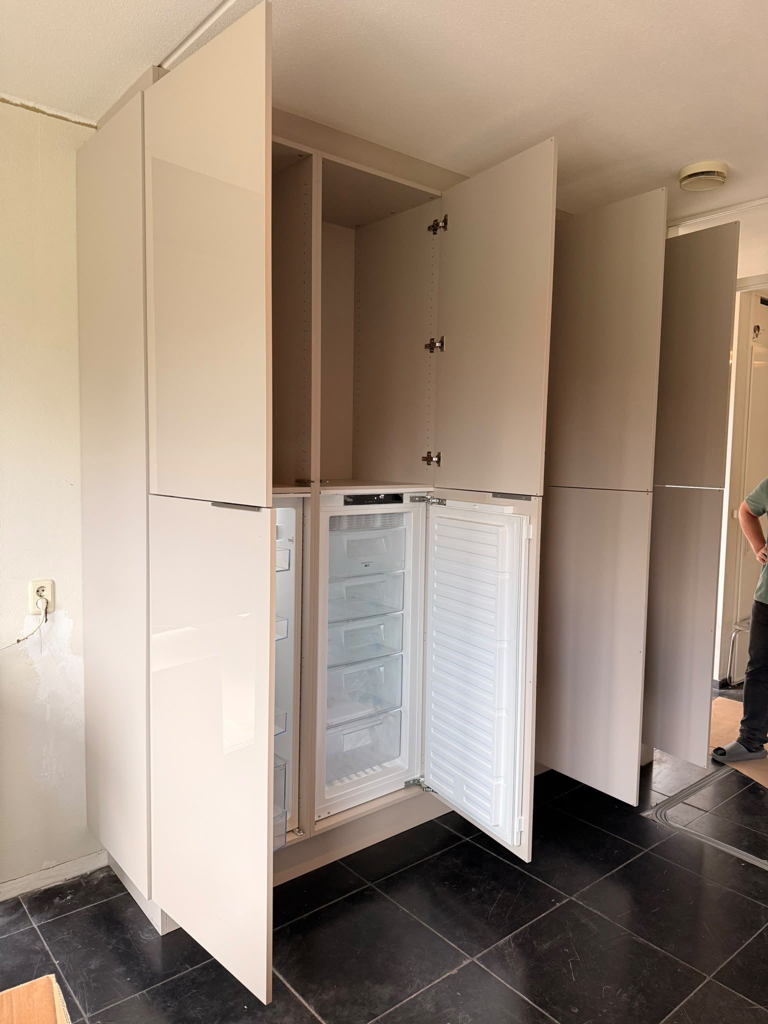 Nieuwe opbergkast met ingebouwde koelkast en vriezer, deuren open