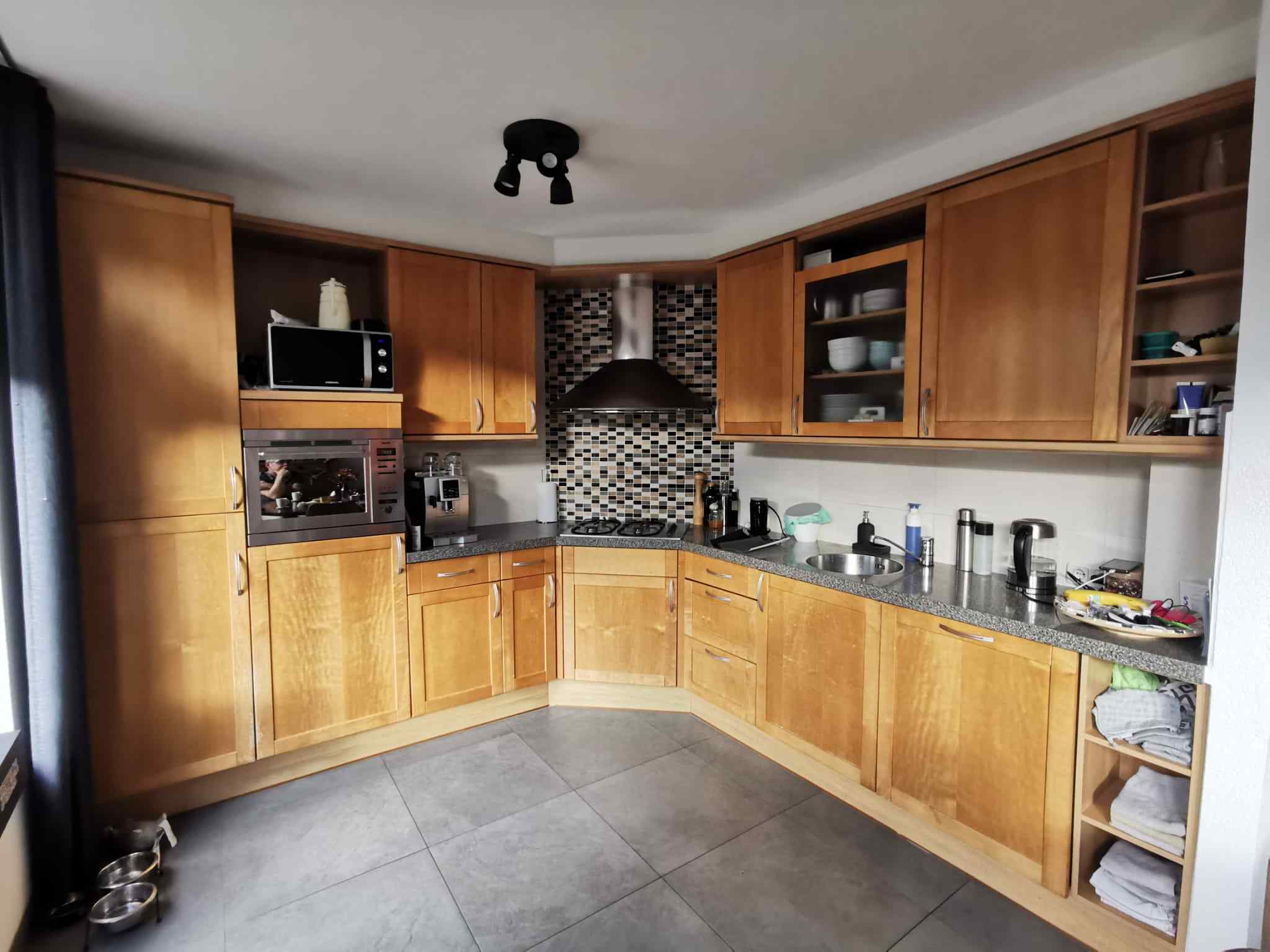 Voor: Eiken keuken met mozaïek-achterwand vóór de renovatie