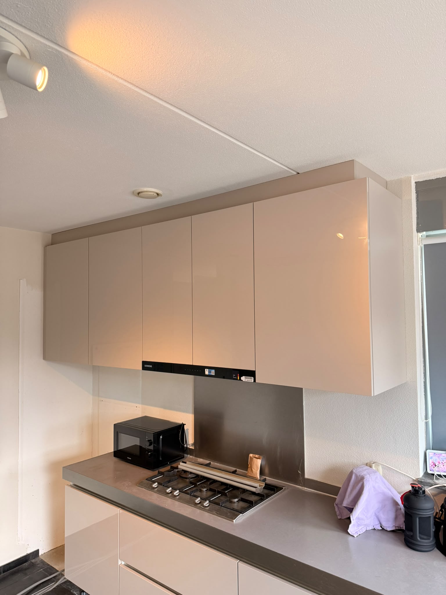 Nieuwe hoogglans hangkasten boven het fornuis met een geïntegreerde afzuigkap