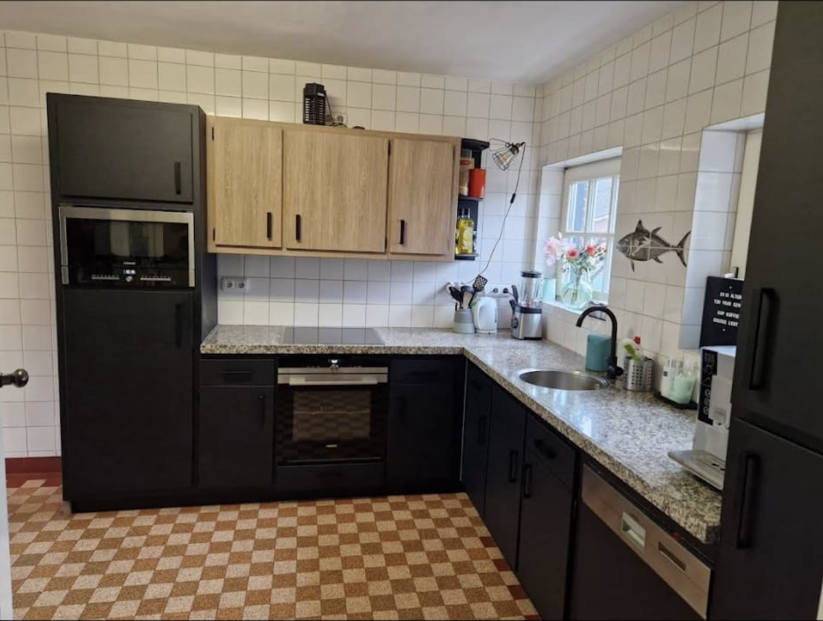 Mat zwarte keuken met eikenhouten bovenkasten